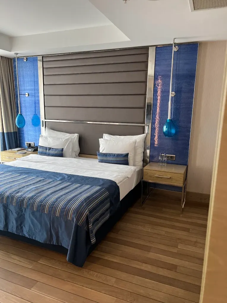 Otel Yatak Başlığı – Krom Çerçeveli Gri Kapitone Panel